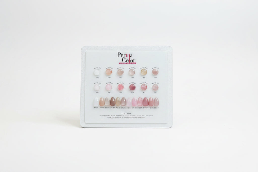 A Perma Color nail polish display card showing 12 different shade options for press-on nails, arranged in rows of three with circular swatches above and elongated nail color samples below on a white card.
