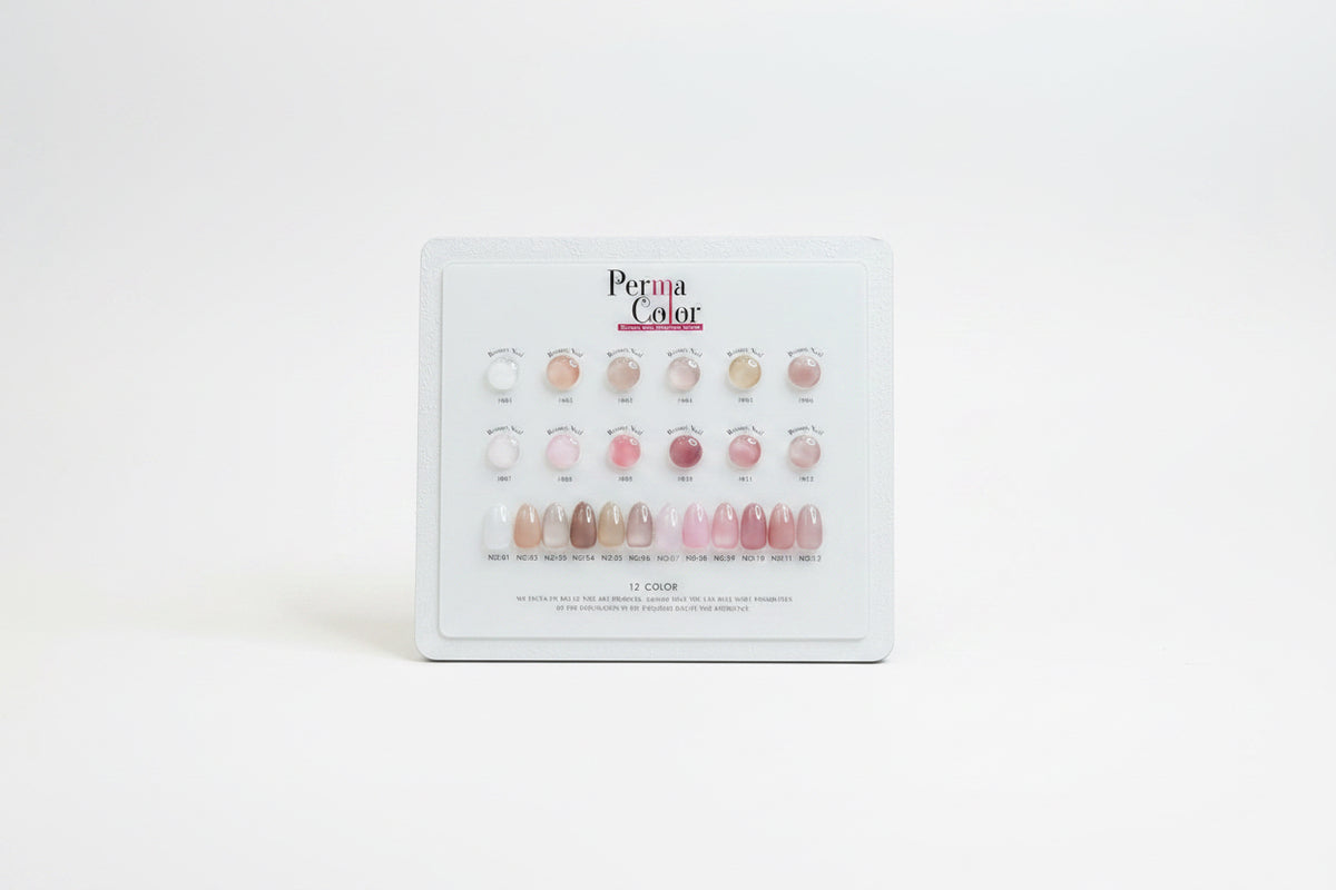 A Perma Color nail polish display card showing 12 different shade options for press-on nails, arranged in rows of three with circular swatches above and elongated nail color samples below on a white card.
