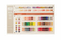 A large JACU nail polish color display board showing 100 color options arranged in rows, photographed on a tabletop with a warm indoor background.