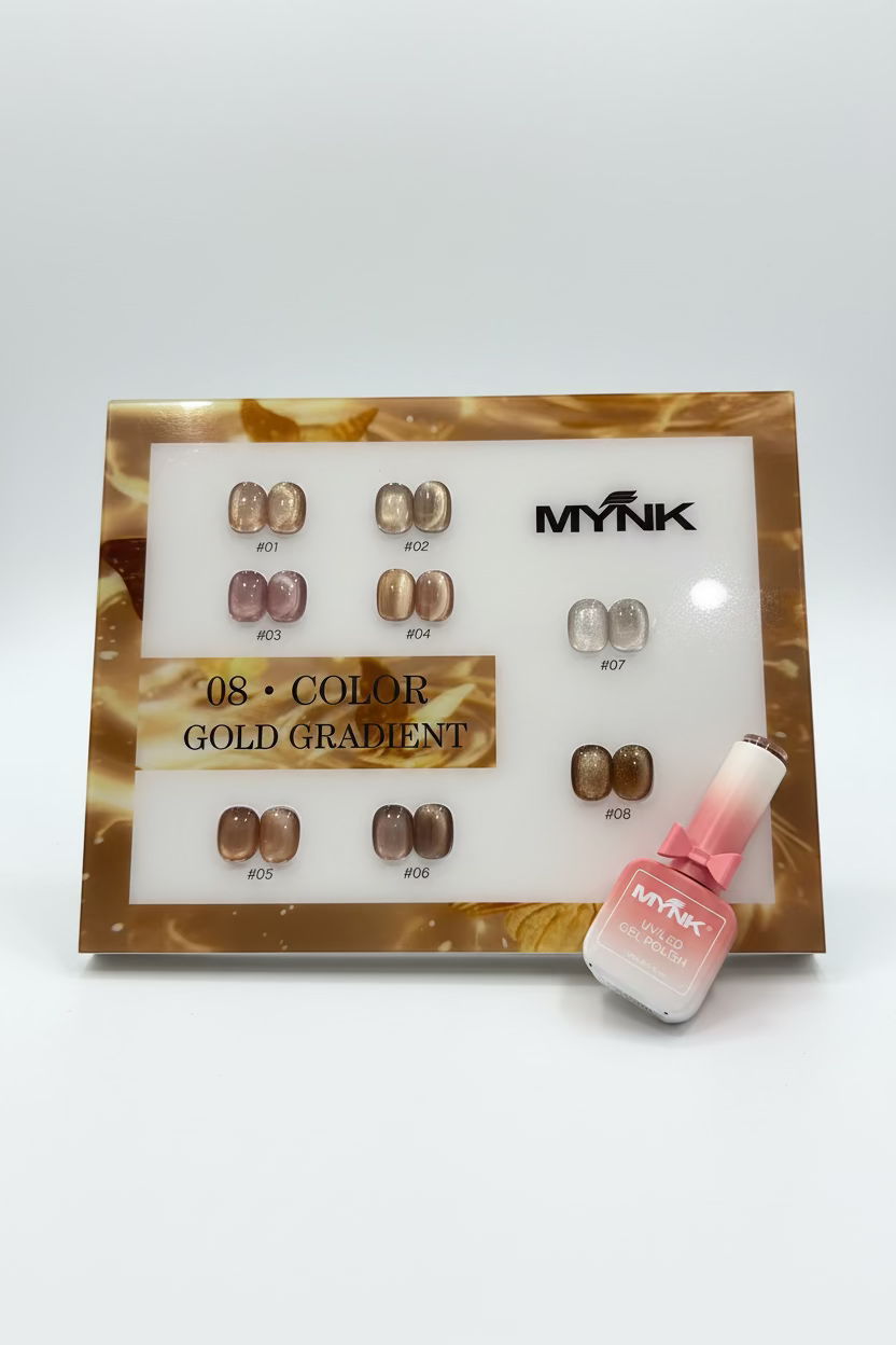 A display card and bottle of MYNK false nail polish showing the shade 08 Color Gold Gradient. The card features eight pairs of nail tips in a gold gradient color, and a bottle of pinkish-gold gradient gel polish is placed next to it on a gray faux fur surface.