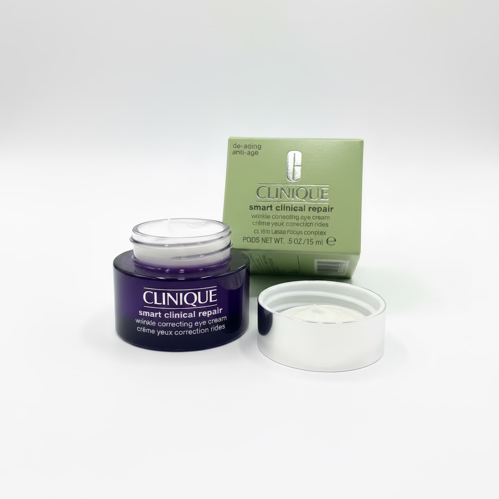 Clinique Smart Clinical Repair eye cream jar and box on a countertop, with the jar open to show the cream, a laptop displaying the product packaging, and a yellow basket in the background.