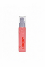 A pink spray bottle of Tinglez Nightgazer insect repellent spray with a clear cap, standing on a glass display counter inside a retail store.