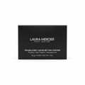 A black Laura Mercier box of Translucent Loose Setting Powder placed on a glass shelf, with a laptop and other cosmetic items in the background.