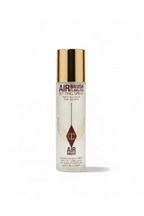 MediCube Air Brush Flawless Setting Spray bottle with a metallic gold cap, displayed on a glass shelf among other skincare packaging.