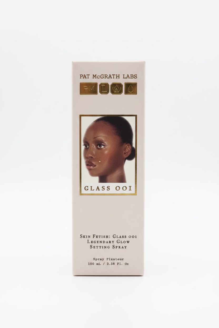 Pat McGrath Labs By Lena Glass Ooi Skin Fetish Legendary Glow Setting Spray box, shown in front of other skincare packaging on a counter.