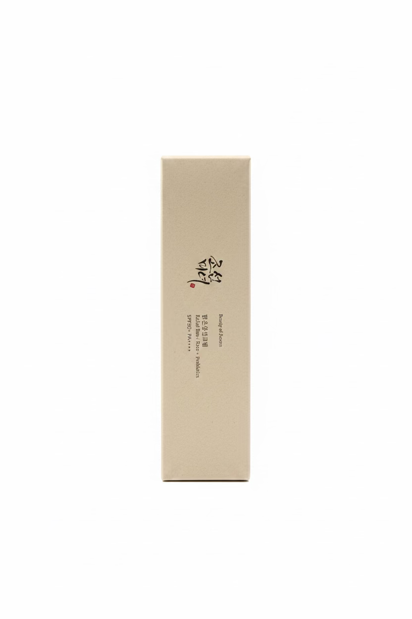 A tall, rectangular beige cosmetic box with black Korean text and a small red mark, standing upright on a glass display counter in a retail setting.
