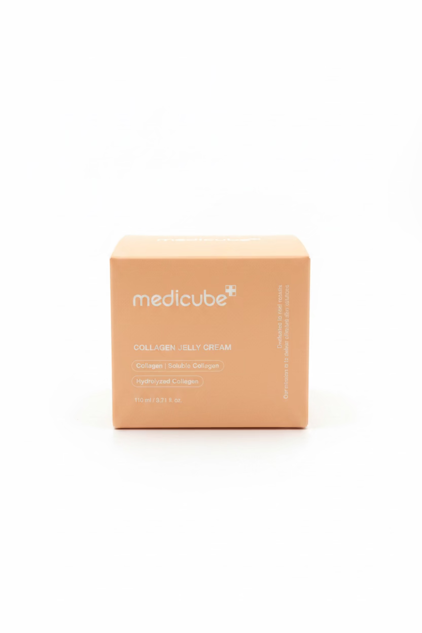 A cardboard box of medicube Collagen Jelly Cream sits on a reflective glass counter in a retail store setting, with shelves of other products blurred in the background.