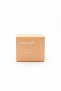 A cardboard box of medicube Collagen Jelly Cream sits on a reflective glass counter in a retail store setting, with shelves of other products blurred in the background.