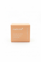 A cardboard box of medicube Collagen Jelly Cream sits on a reflective glass counter in a retail store setting, with shelves of other products blurred in the background.