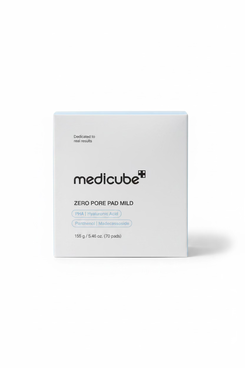 A white box of medicube Zero Pore Pad Mild skincare pads, placed on a glass display counter in a retail store with a laptop and shelves visible in the background.