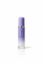A bottle of Atojus Luminous Dry Skin Mist with a purple-to-white gradient cap and body, standing on a reflective glass counter inside a retail store.
