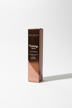 A box of Danessa Myricks Beauty Yummy Skin Glow Serum standing on a glass display counter inside a cosmetics store.