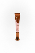 A tube of Yummy Skin Glow & Brighten gel in a brown and pink packaging, standing on a glass display counter inside a retail store.