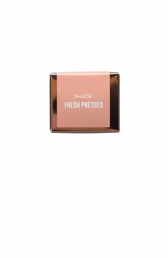 A hand holding a small square pink cosmetic box labeled 'DARK ROSE PALETTE' in a cluttered retail store setting with glass display shelves and products in the background.