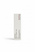 A hand holding a white rectangular box of Rare Beauty Soft Pinch Blush Lévée Love blush in a retail store setting.