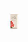 A box of Glow Recipe Watermelon Glow Macadamide Dew Drops stands on a counter in front of an open laptop, with shelves of skincare products in the background.