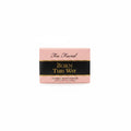 Too Faced Born This Way Effortless Makeup Primer box in pink and black packaging, shown on a glass display counter in a store.