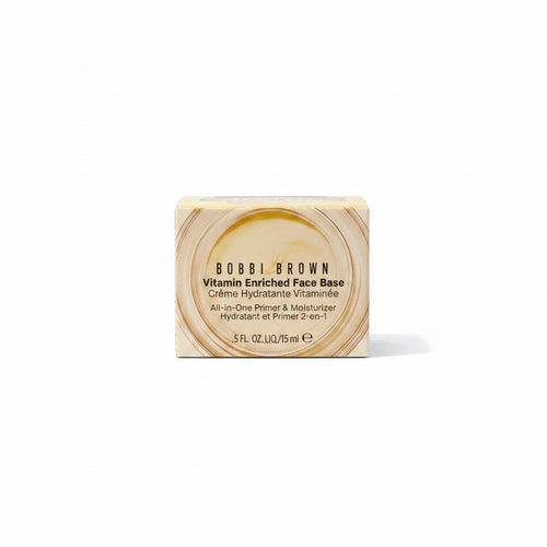Bobbi Brown Vitamin Enriched Face Base in a 5 fl oz box, placed on top of a silver laptop next to a computer screen.