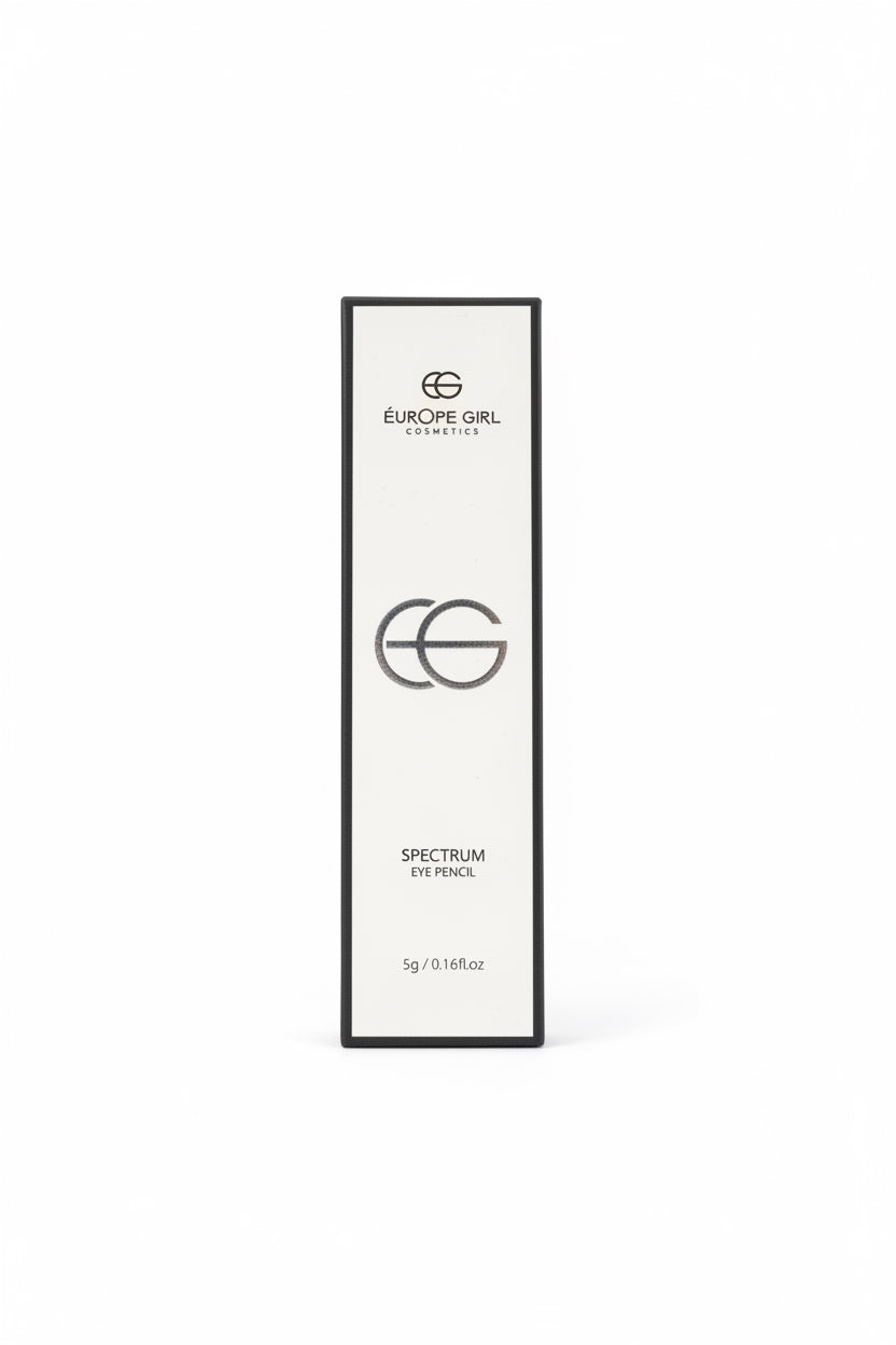 A hand holds a slim white rectangular box for Europe Girl Cosmetics Spectrum French eyeshadow, with the brand name and logo visible on the front. The background shows a person's beige pants and a cluttered desk with other product boxes.