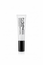 A tube of MAC Studio Radiance Moisturizing Silk Primer standing upright on a glass display counter inside a retail store. The product tube is white with black text and a black cap, with MAC branding clearly visible.