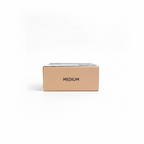 A beige cardboard box labeled 'MEDIUM' sits on a glass shelf in a retail setting, with a gold Mynk package below and a laptop and shelves in the background.