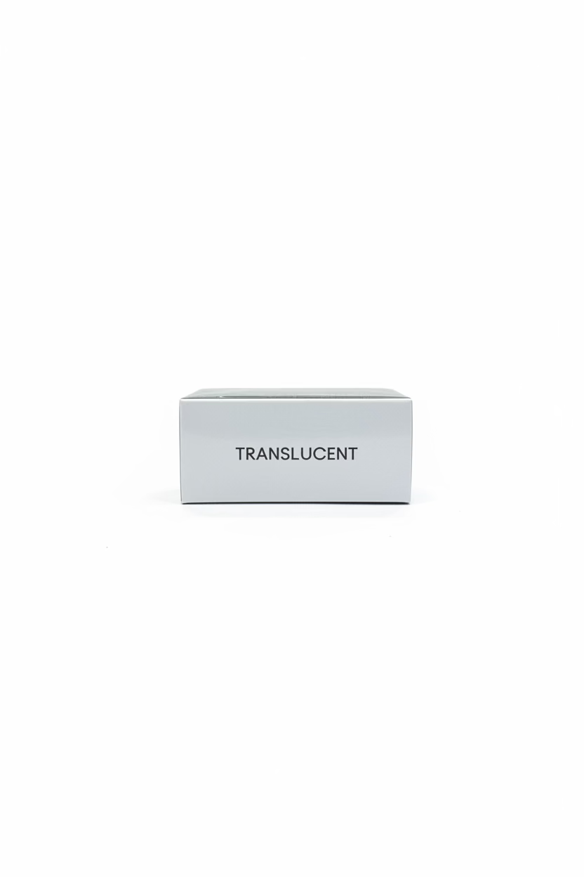 A white rectangular box with the word 'TRANSLUCENT' printed in black on the front, placed on a glass shelf in a retail store. An Apple logo is visible on a laptop at left, and a gold-colored cosmetic pouch with printed text appears below.