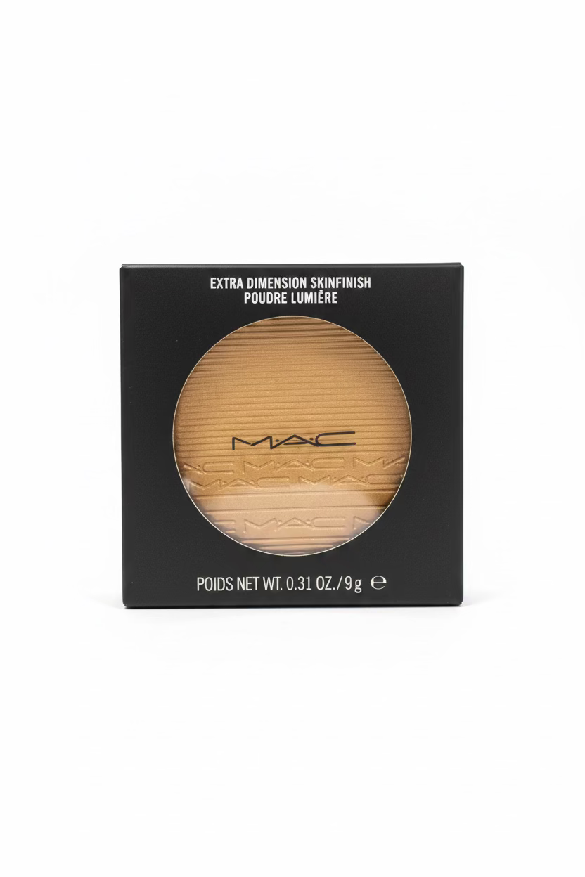 MAC Extra Dimension Skinfinish powder compact in its black retail box, displayed on a glass counter with a laptop and store shelves in the background.