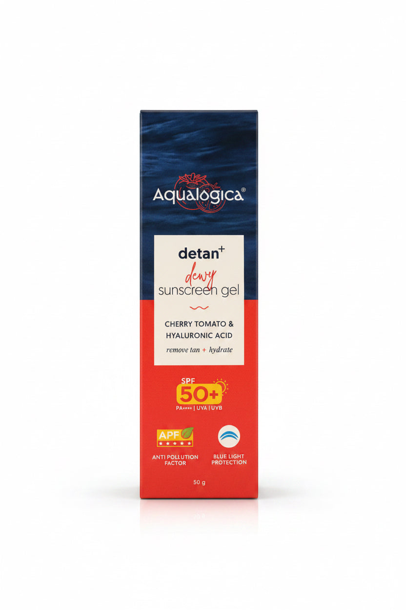 A box of Aqualogica Detan+ Dewy Sunscreen Gel in Cherry Tomato & Hyaluronic Acid, placed on a desk in front of a laptop with shelves of skincare products in the background.