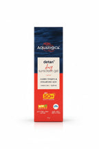 A box of Aqualogica Detan+ Dewy Sunscreen Gel in Cherry Tomato & Hyaluronic Acid, placed on a desk in front of a laptop with shelves of skincare products in the background.