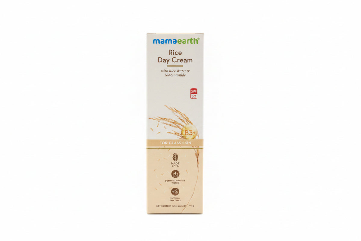 A box of Mama Earth Rice Day Cream stands on a dark countertop in a store or home setting, with a teal basket, other skincare items, and an open laptop nearby.