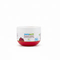 A jar of Mamaearth Beetroot Hydraful Light Moisturizing Cream placed on a dark tabletop in front of a mint green plastic basket, with a laptop partially visible on the right.