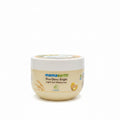 A jar of Mamaearth Rice Dewy Bright Light Gel Moisturizer placed on a dark countertop in front of a mint green plastic storage basket.