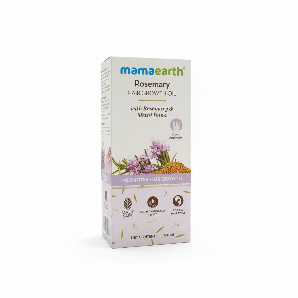 A box of Mama Earth Rosemary Hair Growth Oil placed on a dark reflective desk, with a laptop visible on the left and office items in the background.
