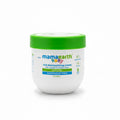 A jar of Mama Earth Baby Rich Moisturizing Cream sits on a laptop keyboard in a home office setting, with other Mama Earth products visible in the background.