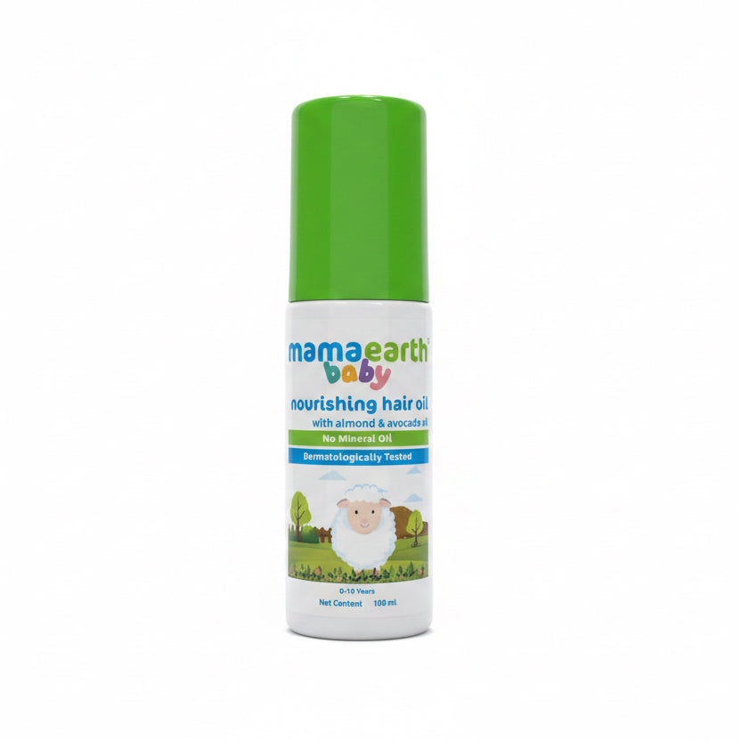 A bottle of Mama Earth Baby nourishing hair oil with a green cap and white label, placed on top of an open laptop in an office setting.