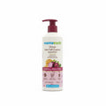 A bottle of Mama Earth Onion Hair Fall Control Shampoo placed on top of an open laptop in an indoor setting, with a chair and shelves visible in the background.