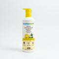 A bottle of Mama Earth Lemon Anti-Dandruff Shampoo placed on top of an open laptop in an indoor setting.