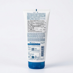 A white tube of Kao Kao makeup cream with a blue cap, showing the detailed product instructions and ingredients on the back, placed on a desk with a keyboard and papers in the background.