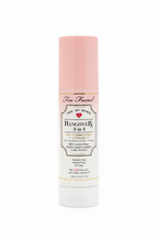 Too Faced Hangover Bx 3-in-1 Hydrating Primer bottle with a pink cap and white label, displayed on a glass counter in a retail setting.