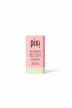 Pixi On-the-Glow Blush tinted moisturizer stick in a pink and pale yellow tube, displayed on a glass shelf in a retail setting.