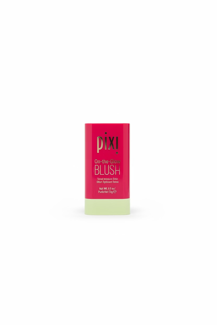 Pixi De-itch-Glow Blush stick in a red and pale yellow tube, displayed on a glass shelf with other cosmetic products in a store setting.