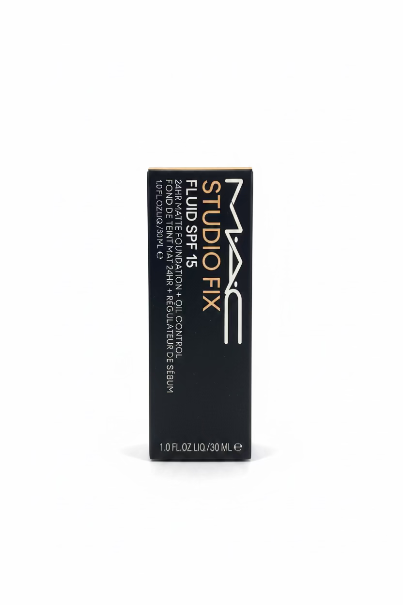 A black box of MAC Studio Fix Fluid SPF 15 standing upright on a glass display counter, with a blurred store background including a laptop, blue boxes, and a hand.