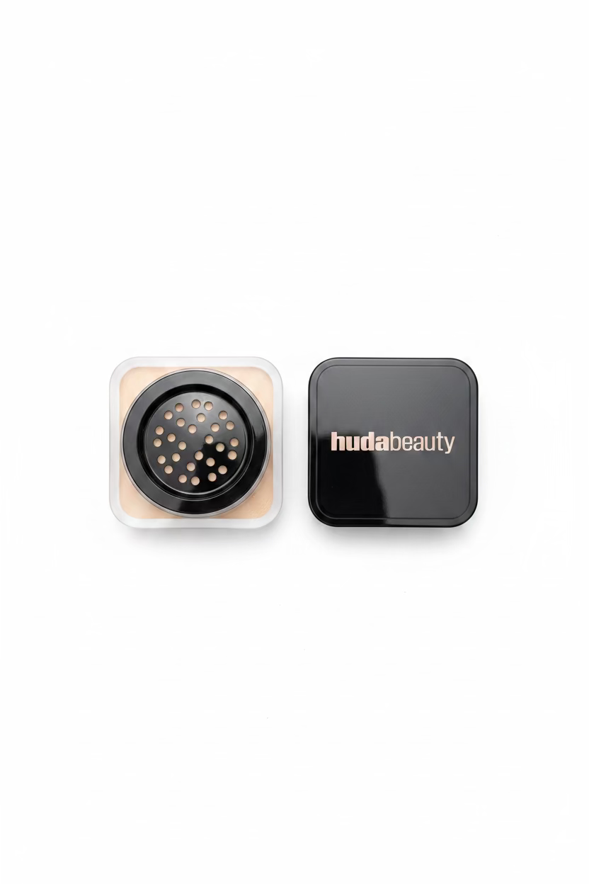 A hand holding a small skincare device with its black lid beside it. The device has a circular black face mask applicator with many small white nozzles, and the lid is branded 'hudabeauty'.